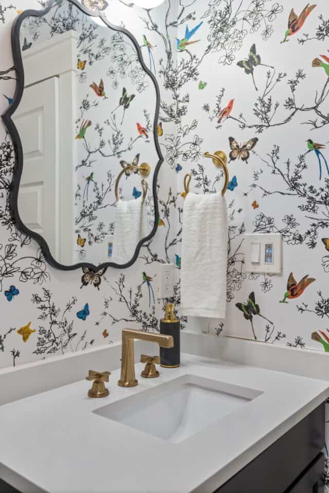 Decorative bathroom with butterfly and bird wallpaper.