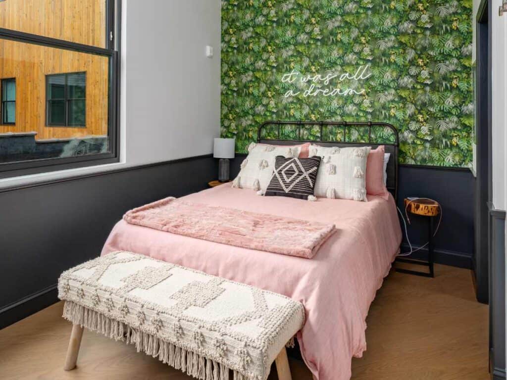 Cozy short-term rental bedroom in Birmingham with green wall decor and stylish furnishings.