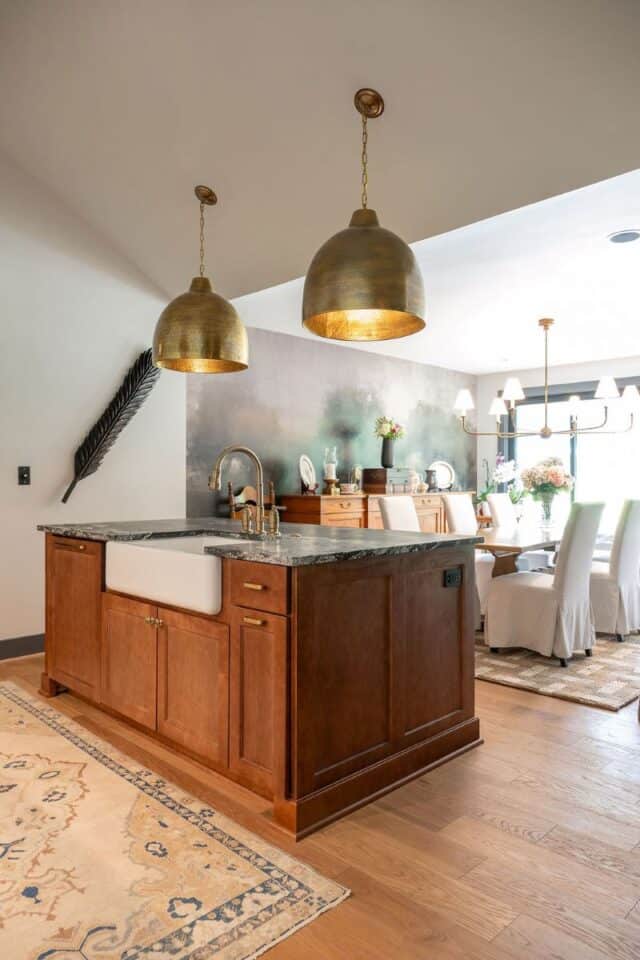 Elegant kitchen with wooden cabinetry and gold pendant lighting.
