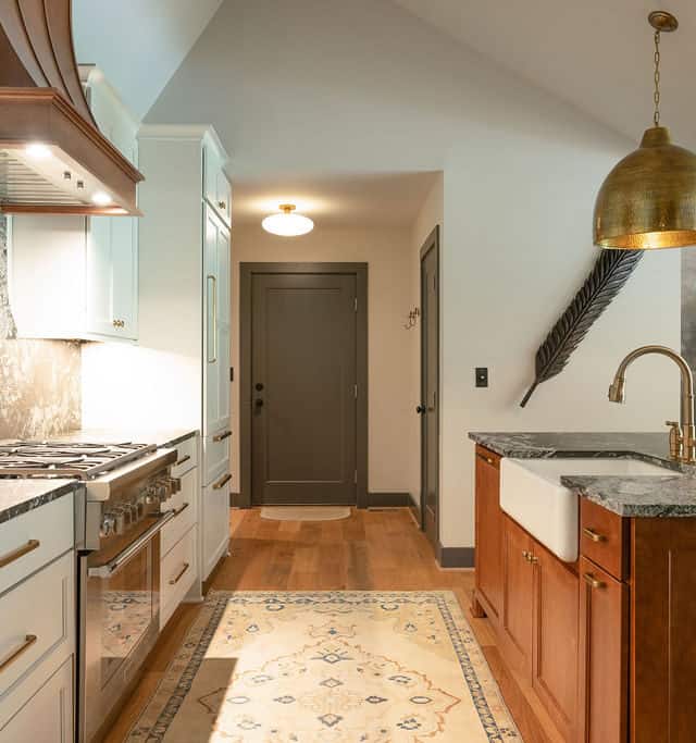 Bright modern kitchen with white and wood cabinetry, granite countertops, and stylish pendant lighti.