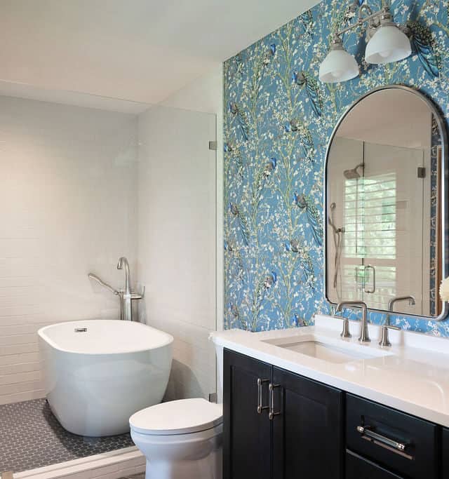 Elegant bathroom with freestanding tub and vibrant wallpaper.