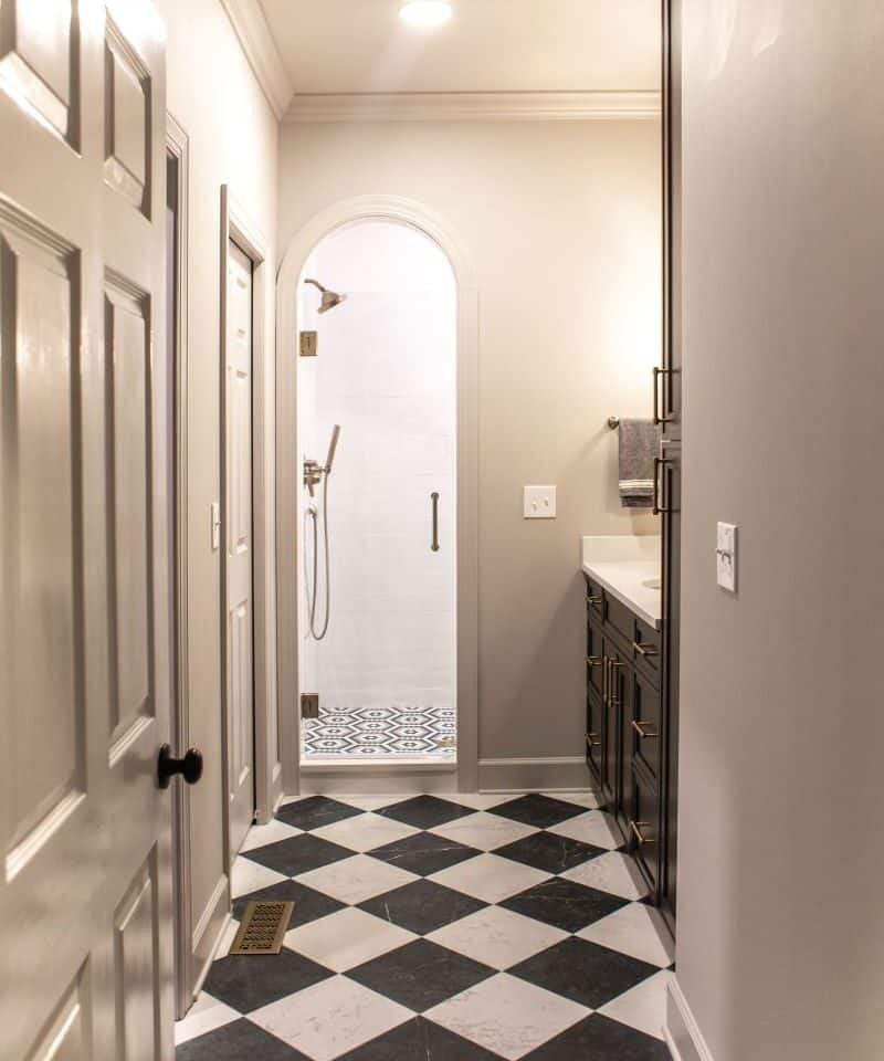 Primary suite bathroom with walk-in shower and elegant black-and-white checkered flooring.