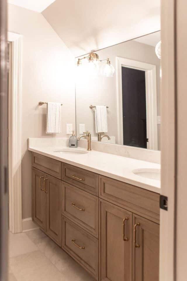 Elegant primary bathroom with dual vanities and stylish lighting.