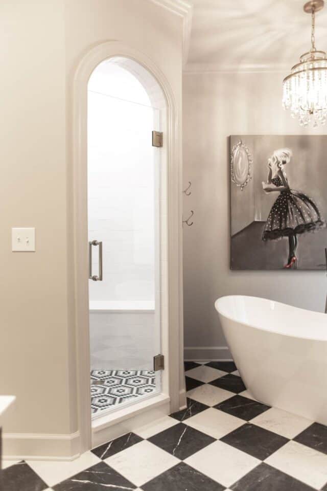 Elegant primary bathroom with a freestanding tub and glass shower.