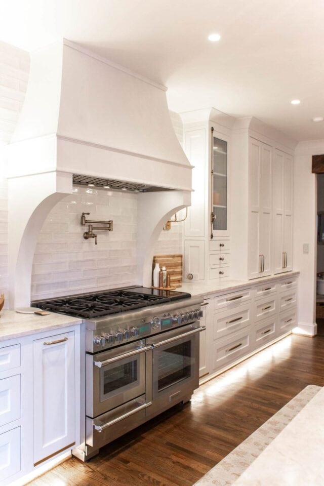 Elegant white kitchen with custom cabinetry and a professional-grade stove for a heart-of-the-home r.