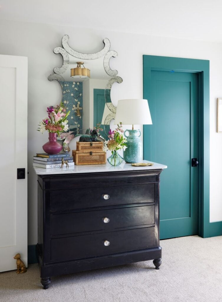 Elegant guest nook featuring a black dresser, mirror, and floral decor for a welcoming 2024 Birmingh.